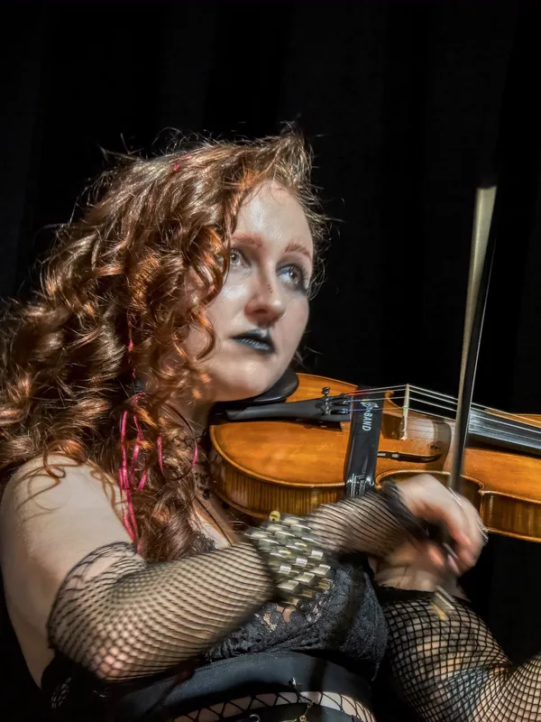 Briana Kennedy playing the fiddle on stage